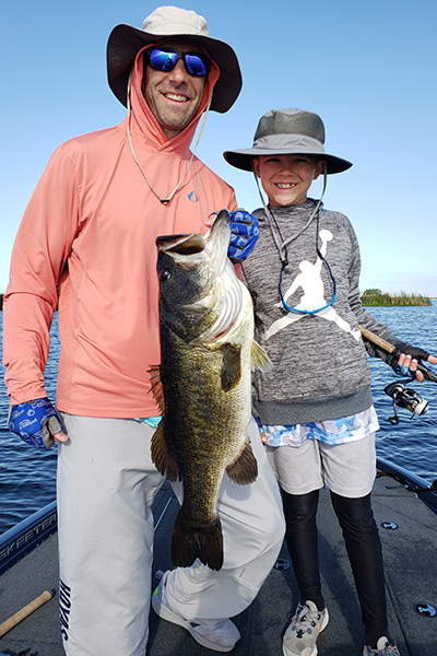 Father and Son holding a big largemouth bass from headwaters lake or stickmarsh near Fellsmere, FL